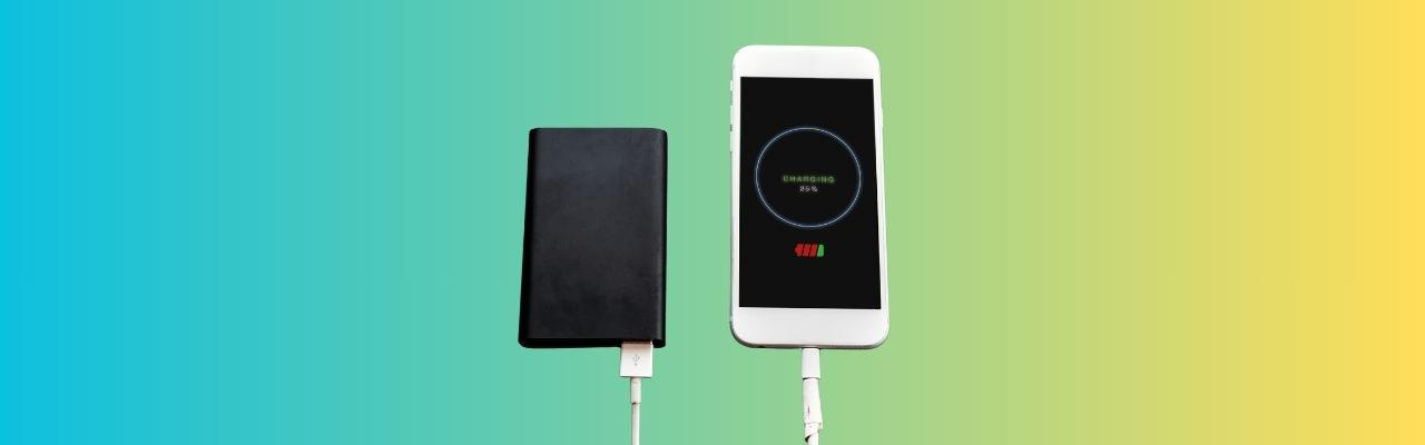 Su uno sfondo sfumato che da sinistra a destra parte dal colore azzurro e arriva fino al giallo vi sono uno smartphone bianco e un power bank nero