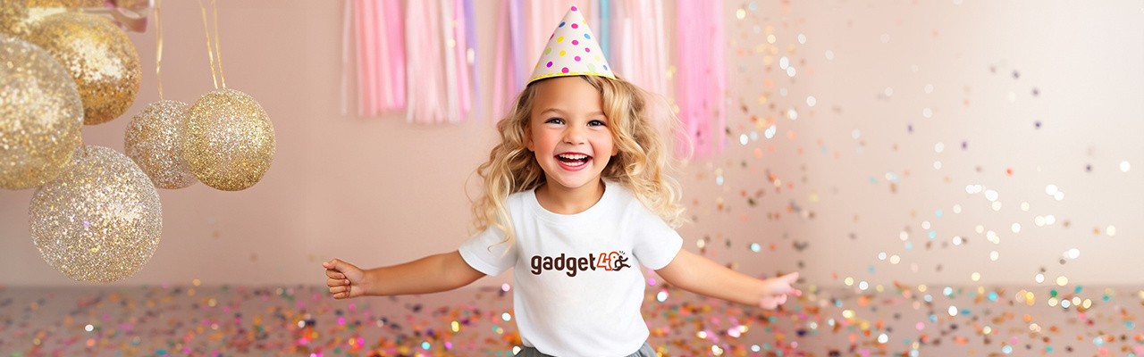 Bambina riccia bionda con t-shirt personalizzata e cappello di compleanno su sfondo a tema festa