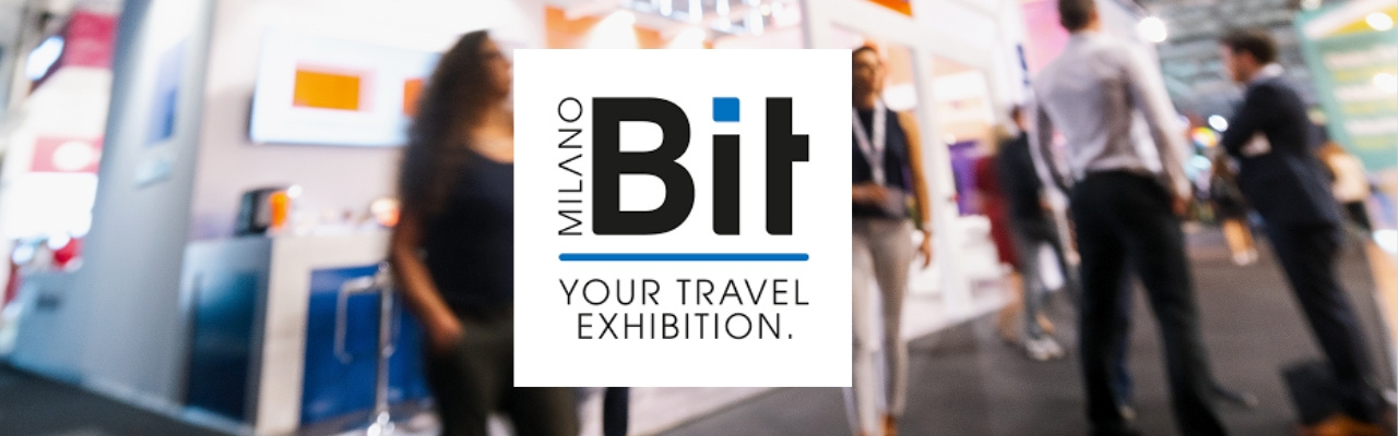 Sullo sfondo delle persone ad una fiera di settore e in primo piano il logo della fiera BIT di Milano