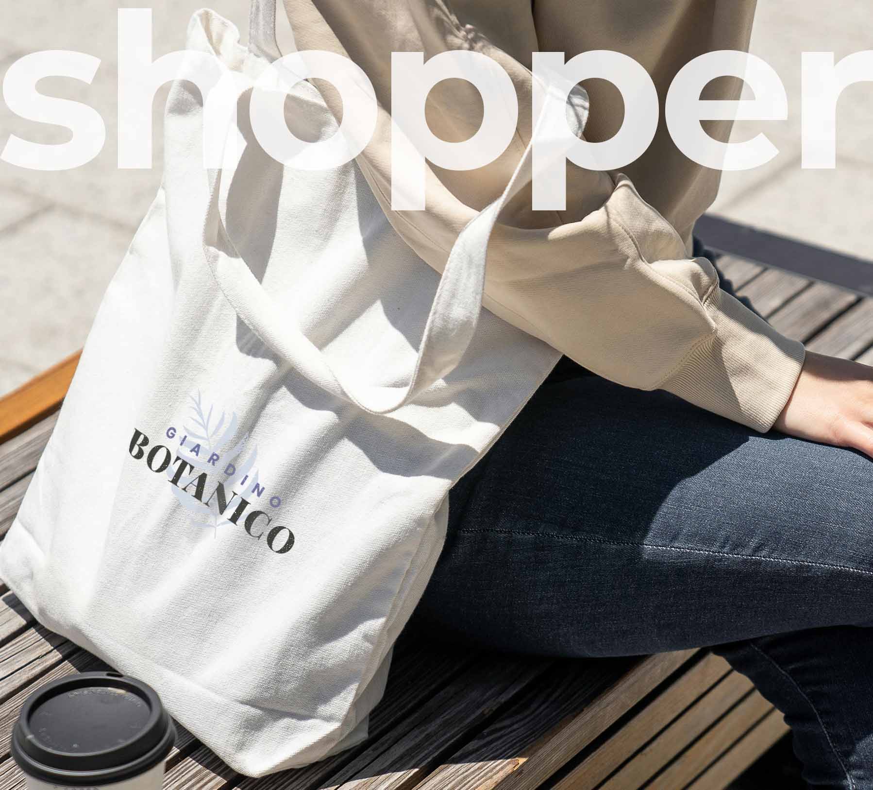 Ragazza seduta su una panchina di legno con una tote bag con scritta stampata e grafica di testo bianco in opacità in alto centrale