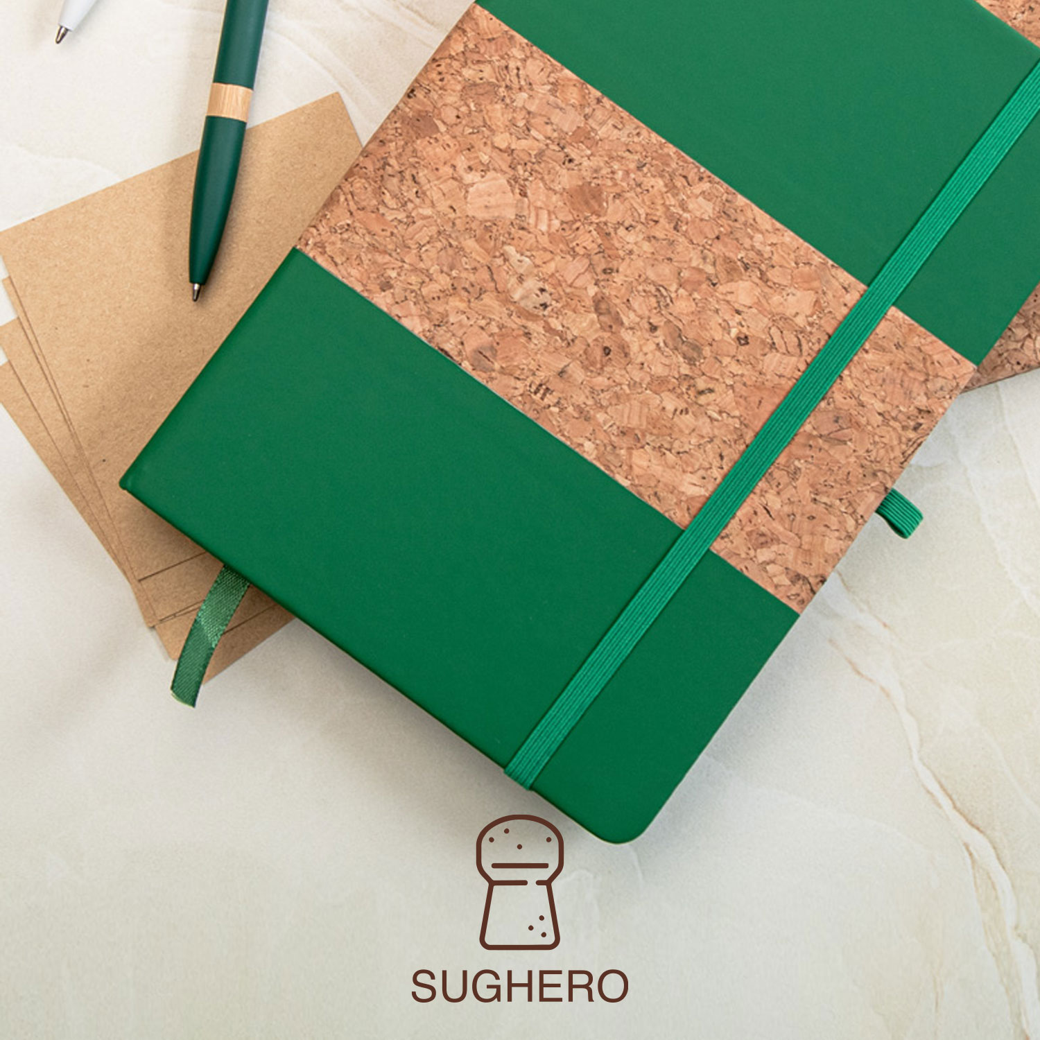 Quaderno verde con fascia centrale in sughero su tavolo di marmo