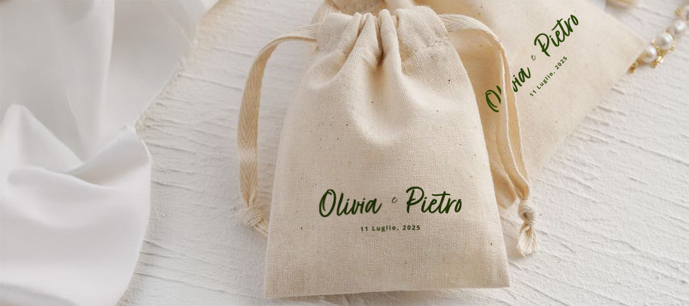 sacca in cotone piccola con stampa verde dei nomi degli sposi e data del matrimonio su tavolo bianco