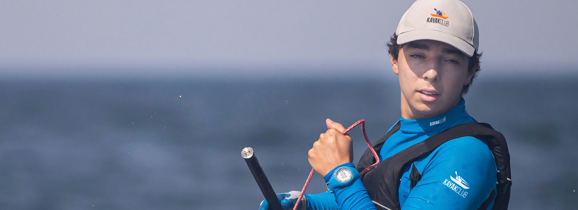 Ragazzo con abbigliamento sportivo che conduce una barca a vela