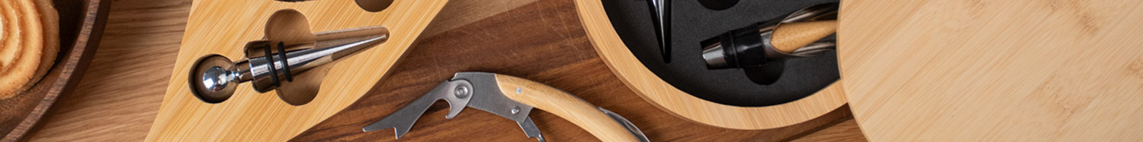 tavolo di legno visto dall'alto con sopra due set vino in bambù e un cavatappi in bambù e acciaio