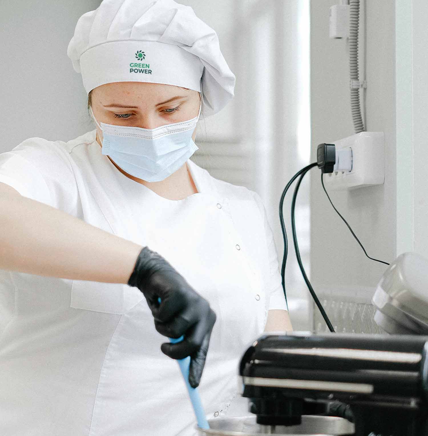 Ragazza che indossa casacca bianca e cappello da chef personalizzato per il team building cooking