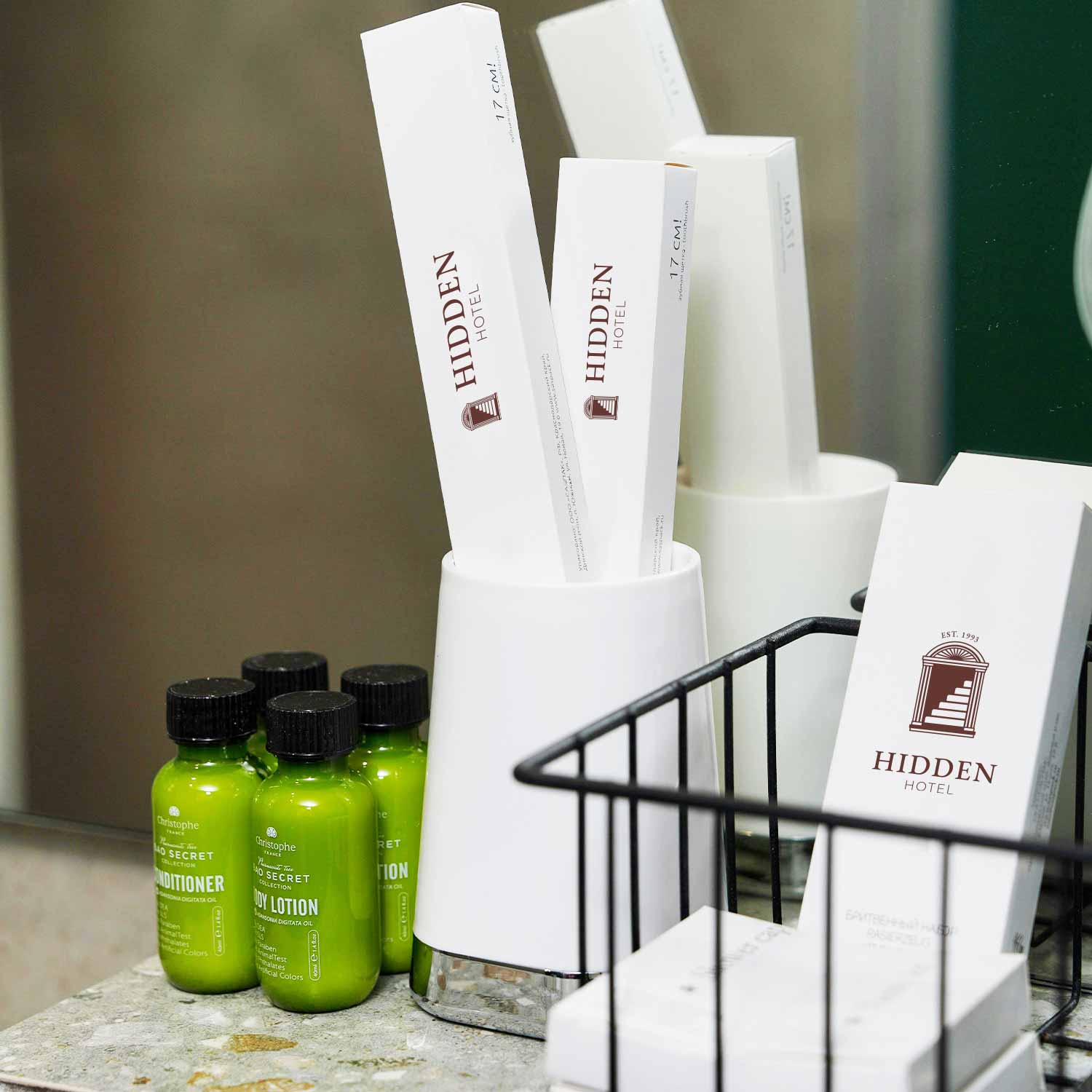 Ripiano di un bagno in marmo con un piccole scatole brandizzate di un kit di benvenuto per hotel. 