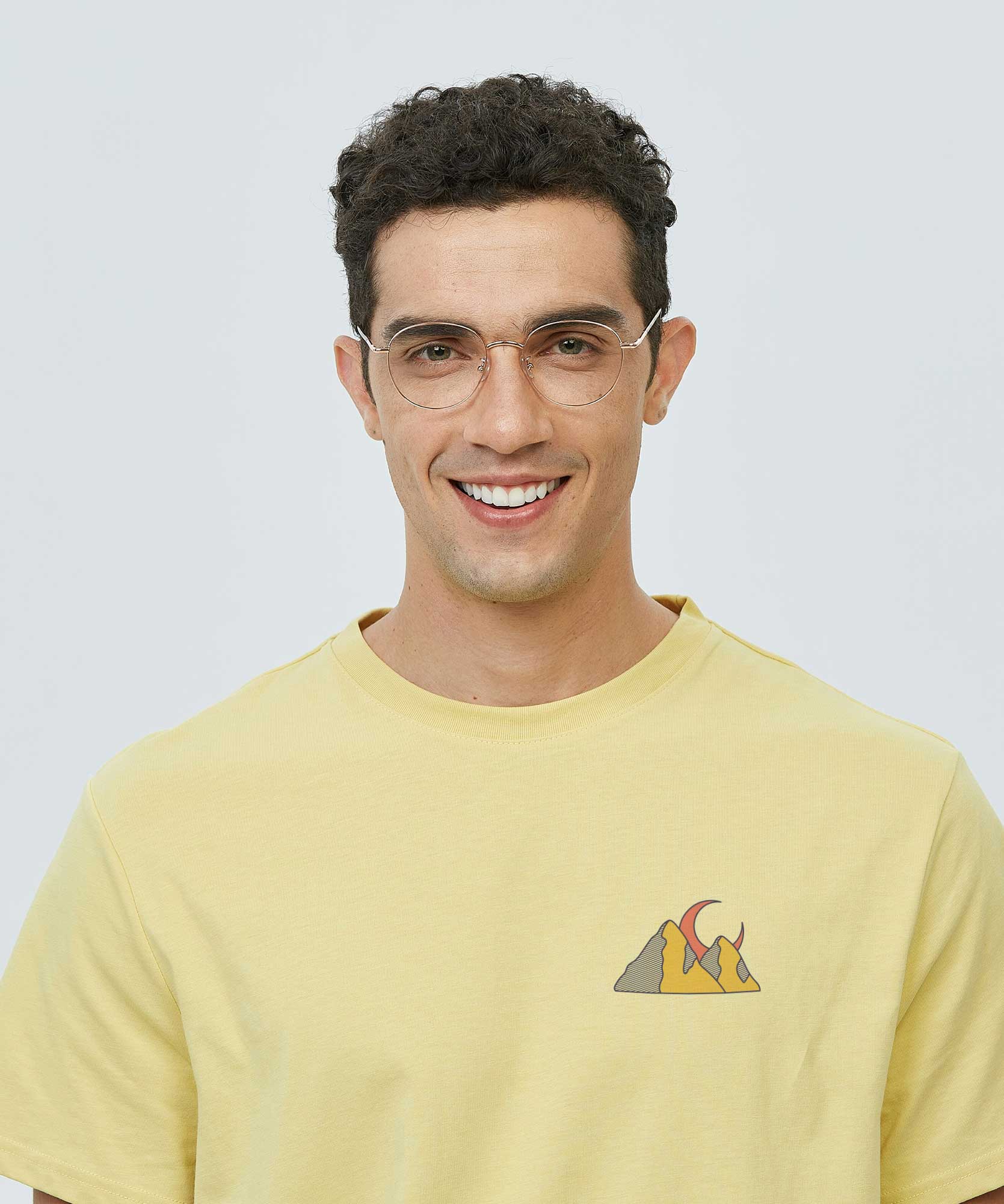 Ragazzo con indosso una maglietta color giallo pastello con una stampa colorata e complessa, realizzata con la tecnica del DTF.