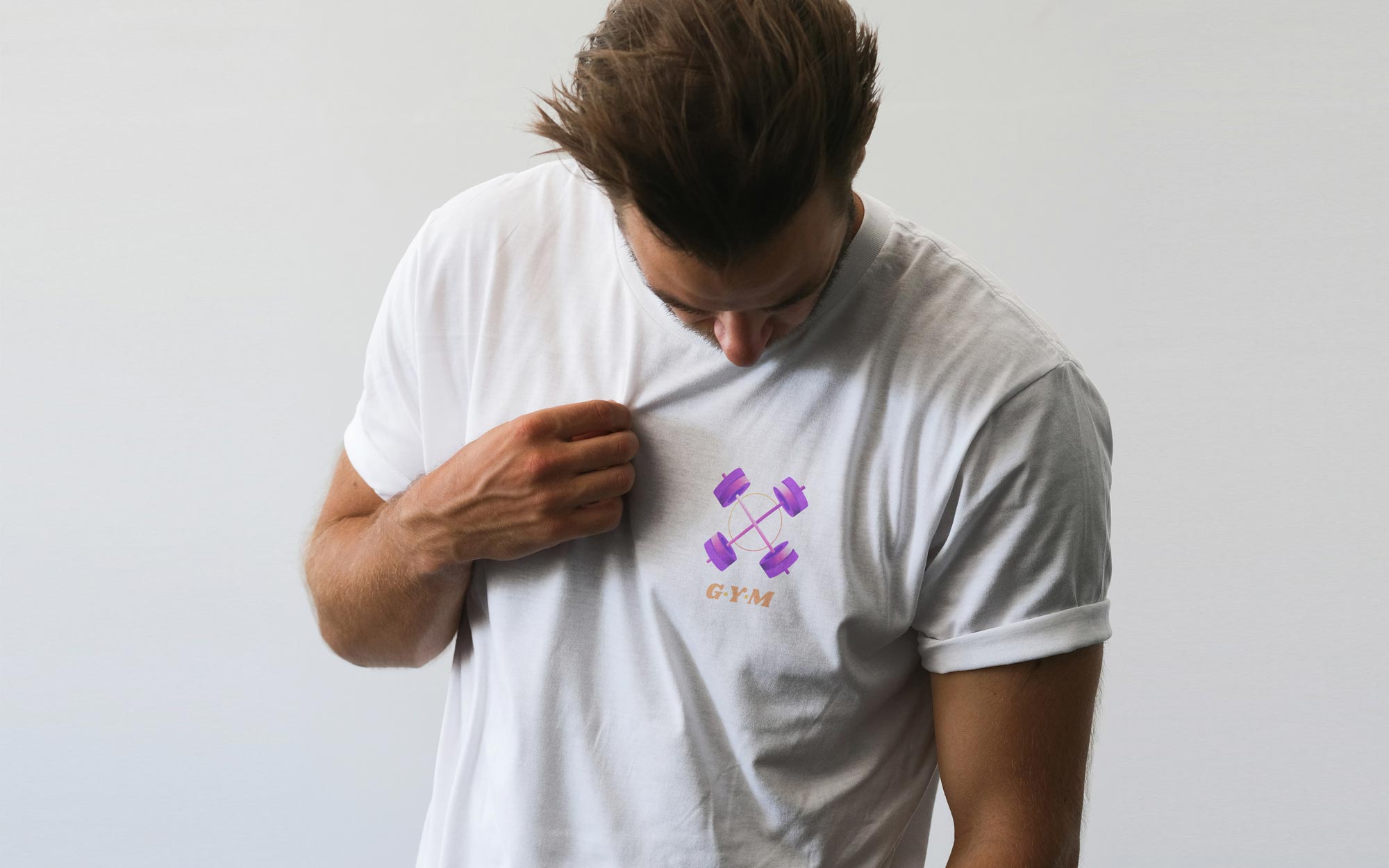 Ragazzo con una t-shirt bianca personalizzata con un logo colorato sul lato cuore. Background bianco.